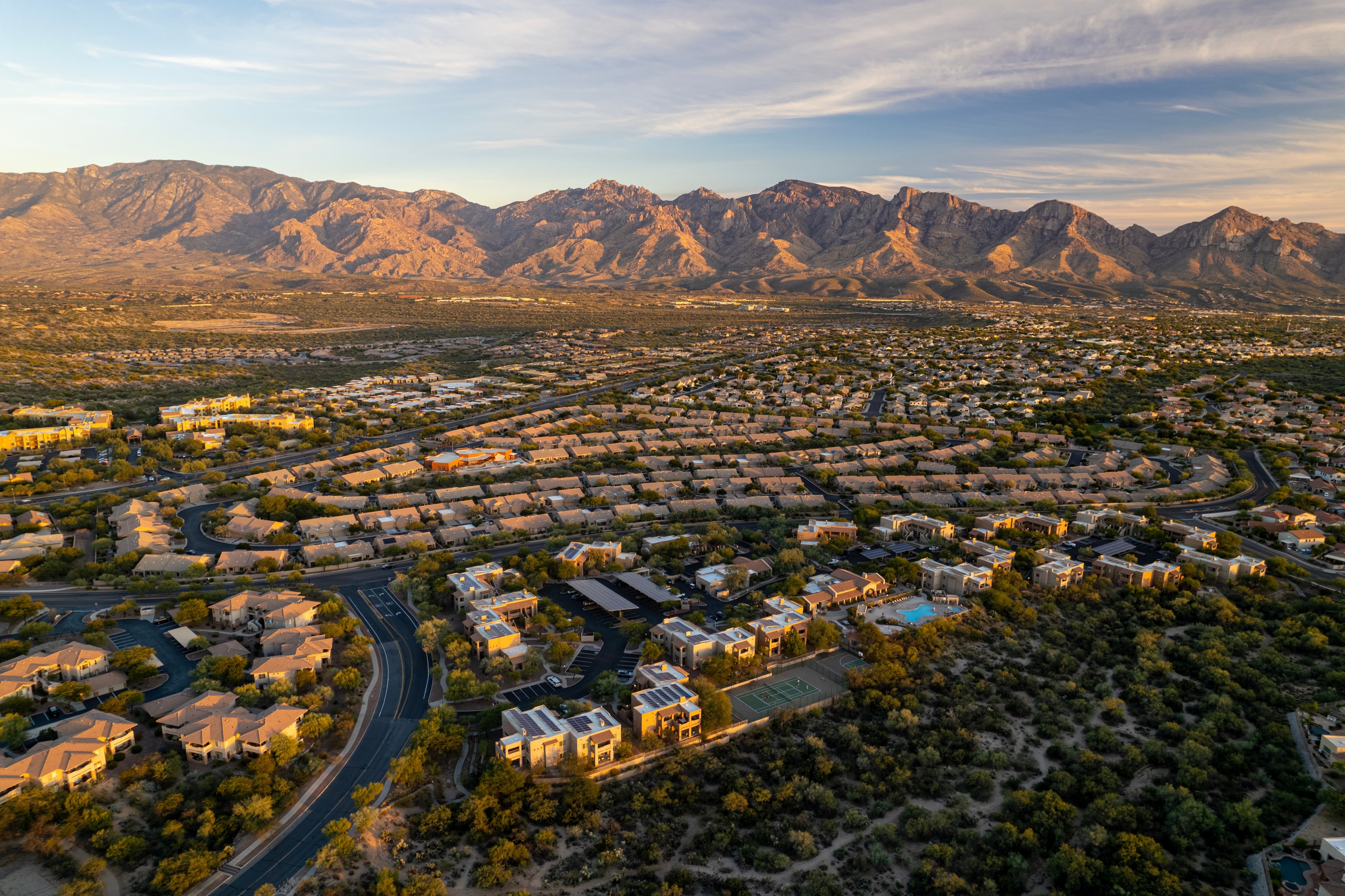 Oro Valley neighborhoods at sunset below the Santa Catalina Mountains, seen from the air